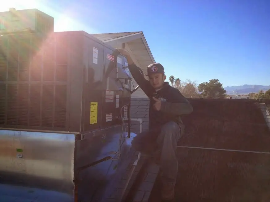 HVAC technician performing AC Tune-Up on a rooftop unit in Georgetown