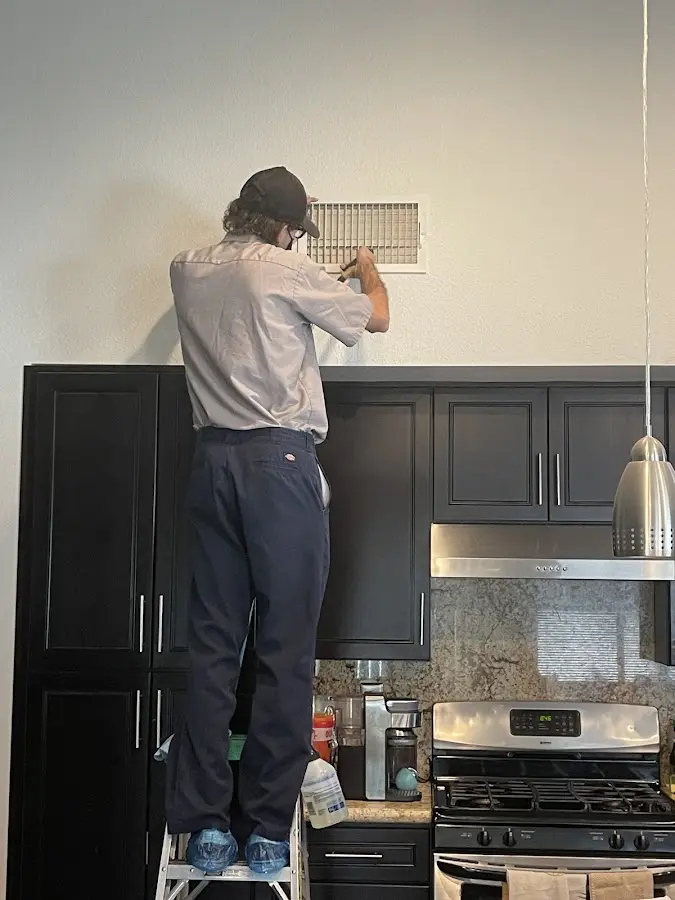 Technician inspecting an air vent during HVAC service in Georgetown